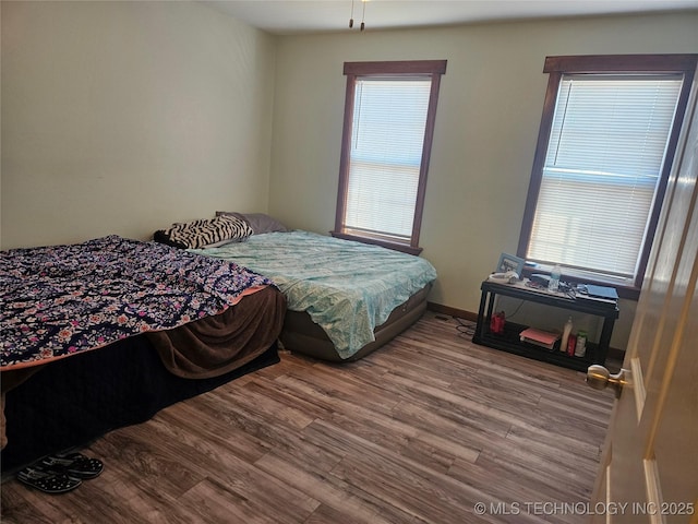 bedroom featuring multiple windows and hardwood / wood-style floors