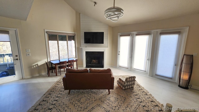 living room featuring light wood-type flooring, lofted ceiling, and a fireplace