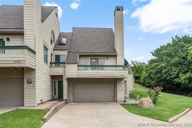 view of front of property with a balcony, a front lawn, and a garage