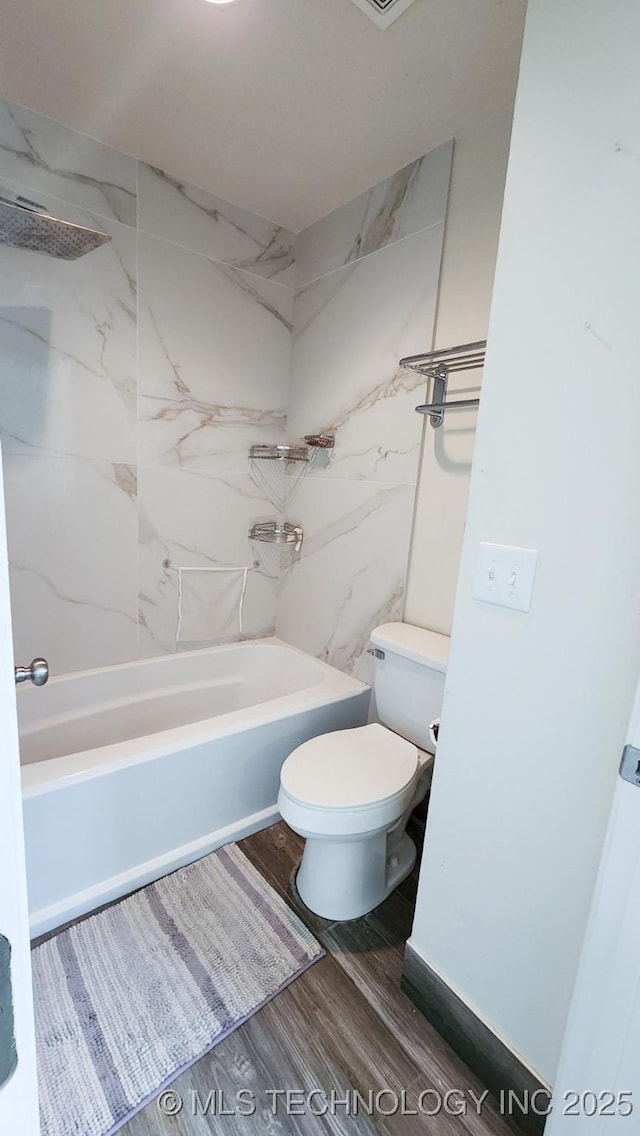 bathroom featuring toilet, tiled shower / bath combo, and hardwood / wood-style flooring