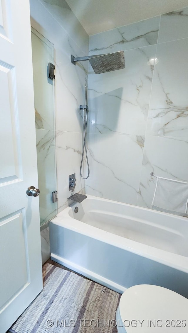 bathroom featuring toilet and tiled shower / bath combo