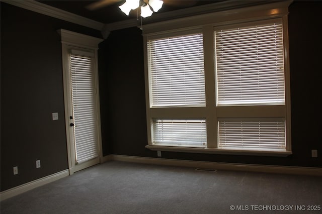 carpeted spare room featuring ceiling fan and ornamental molding