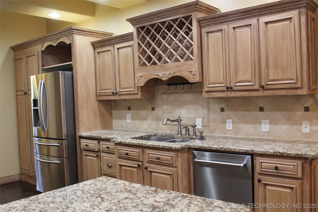 kitchen with appliances with stainless steel finishes, decorative backsplash, light stone counters, and sink