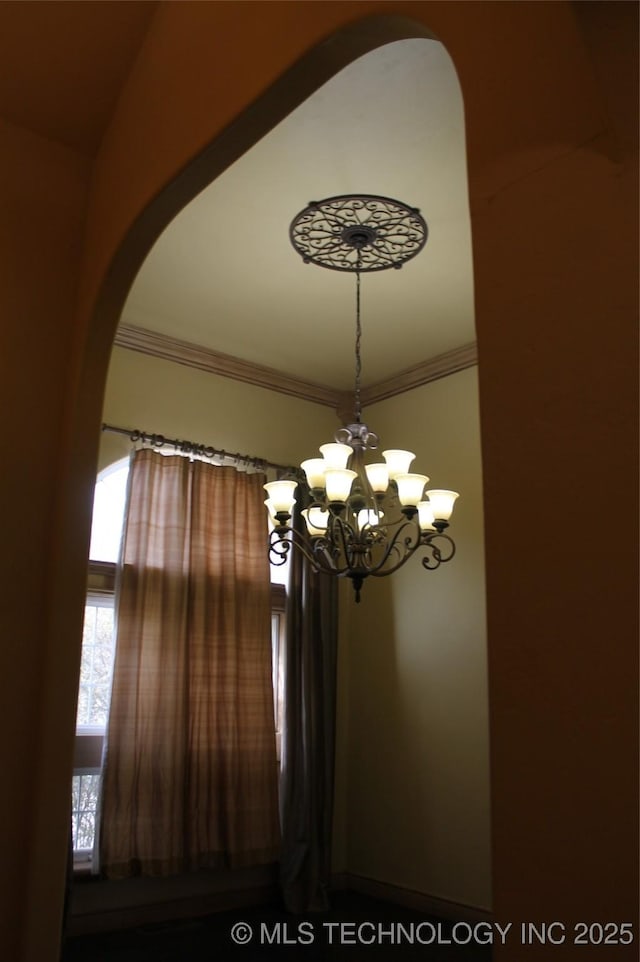 interior details with a chandelier and ornamental molding