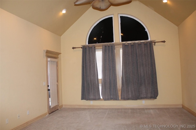 carpeted empty room featuring ceiling fan and vaulted ceiling