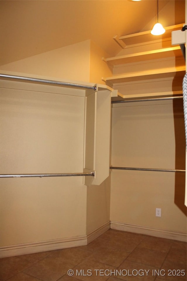 walk in closet featuring lofted ceiling and tile patterned floors