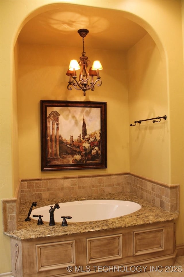 bathroom featuring a bathtub and an inviting chandelier