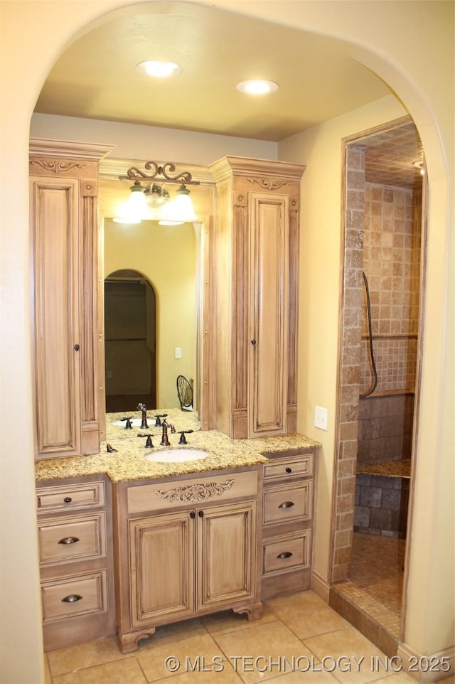 bathroom with tile patterned floors, walk in shower, and vanity