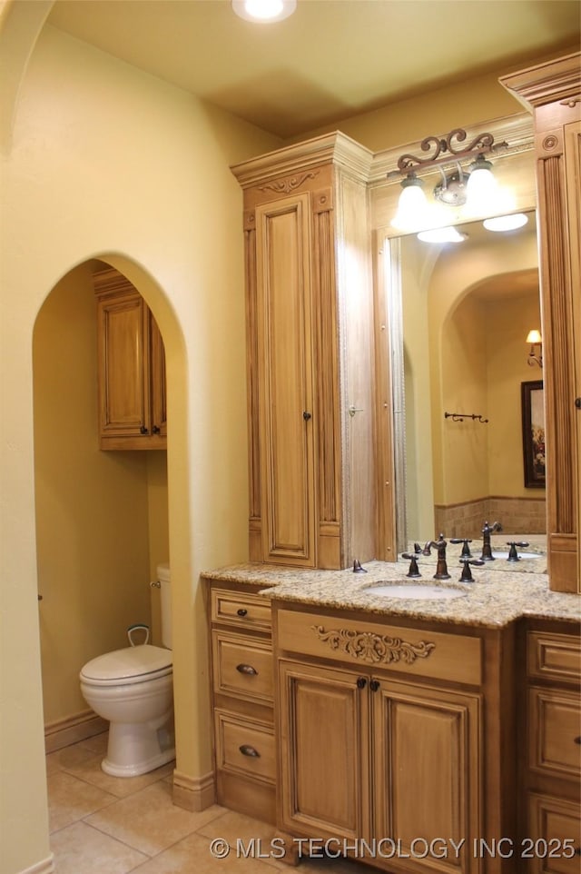 bathroom with toilet, tile patterned floors, and vanity