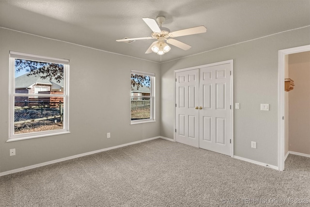 unfurnished bedroom featuring ceiling fan, a closet, and carpet floors