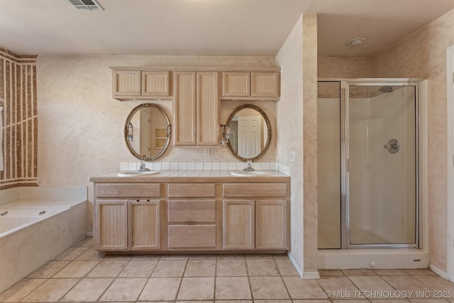 bathroom with a textured ceiling, tile patterned floors, separate shower and tub, and vanity