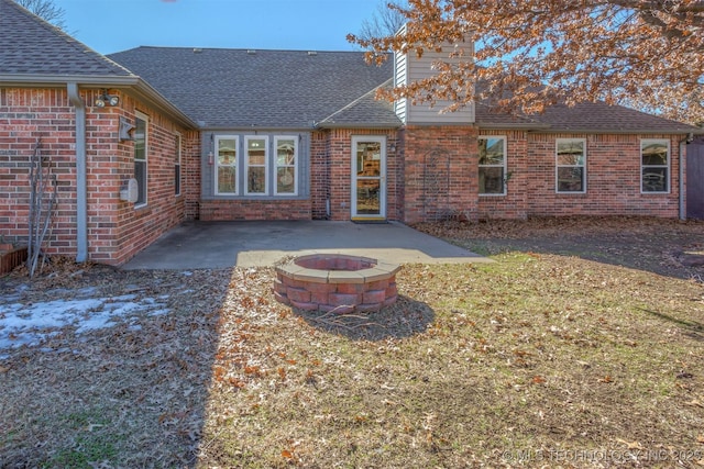 back of property featuring a fire pit and a patio