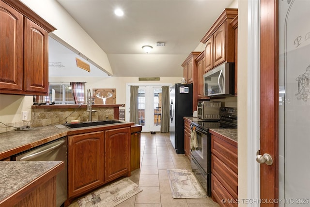 kitchen with black appliances, light tile patterned floors, sink, and lofted ceiling