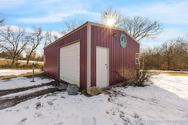 snow covered structure with a garage