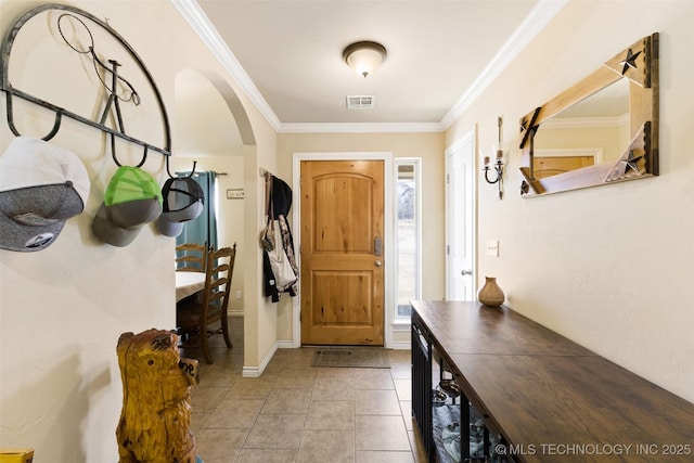 tiled foyer featuring crown molding