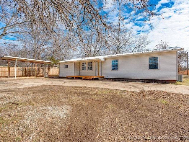 view of front of home with a carport and central AC unit