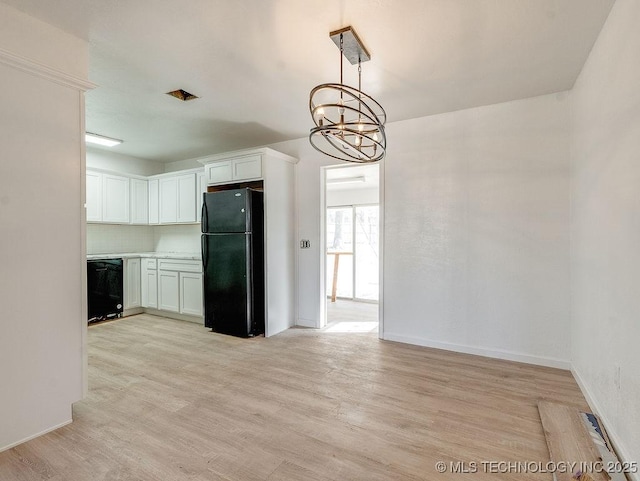 kitchen featuring pendant lighting, white cabinets, light hardwood / wood-style floors, and black appliances