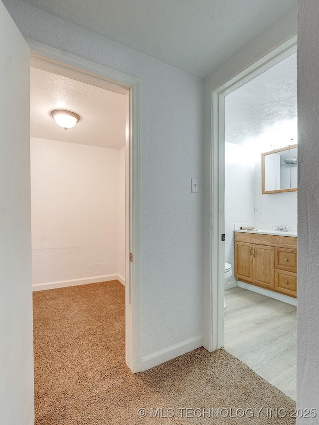 hallway featuring light colored carpet