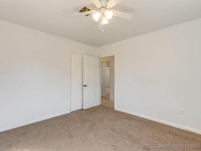 carpeted spare room with ceiling fan