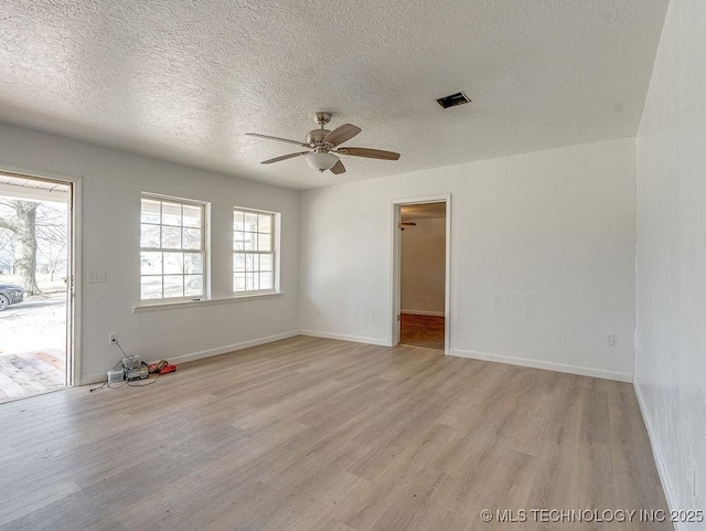 spare room featuring ceiling fan, light hardwood / wood-style flooring, and a textured ceiling