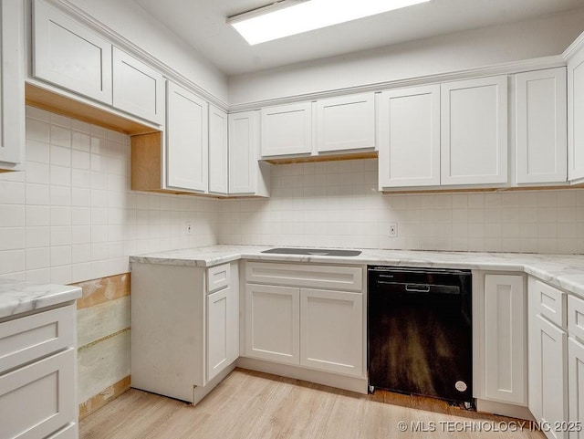 kitchen featuring light hardwood / wood-style flooring, white cabinetry, black dishwasher, tasteful backsplash, and light stone countertops