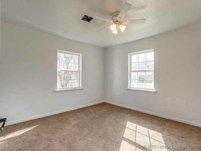 spare room featuring ceiling fan, carpet, and a textured ceiling