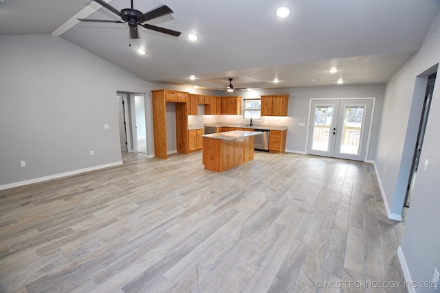 kitchen with dishwasher, a center island, lofted ceiling, french doors, and light hardwood / wood-style floors