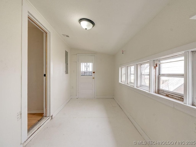 hall with vaulted ceiling and electric panel