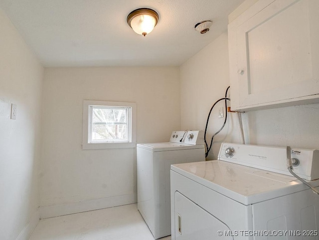 washroom with cabinets and washing machine and dryer