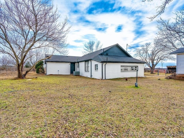 back of house featuring central AC unit and a yard