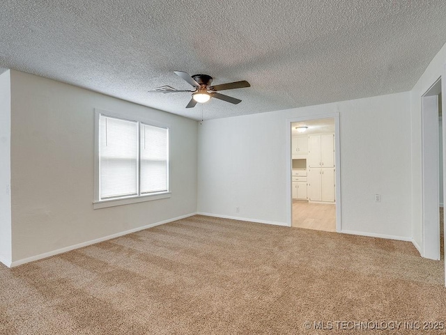 carpeted spare room featuring ceiling fan and a textured ceiling