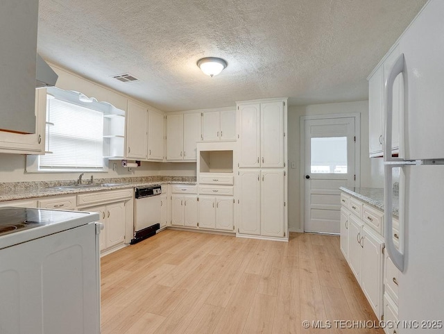 kitchen with sink, light hardwood / wood-style flooring, white cabinets, and white appliances