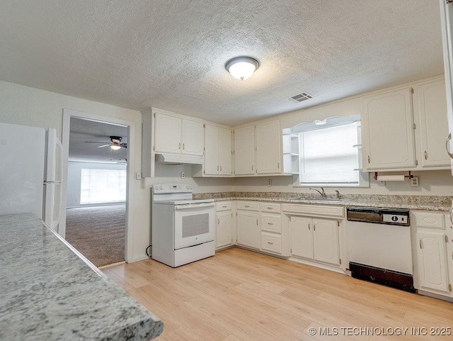 kitchen with sink, white appliances, light hardwood / wood-style flooring, a textured ceiling, and white cabinets