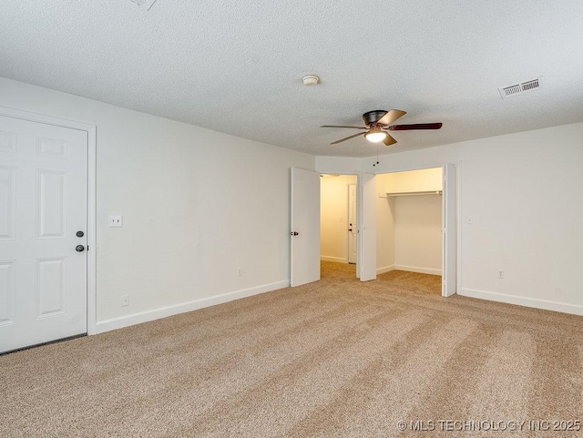 carpeted empty room with ceiling fan and a textured ceiling