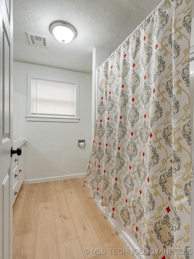 bathroom featuring hardwood / wood-style flooring and a textured ceiling