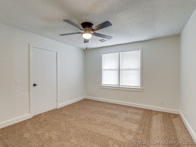 spare room with ceiling fan, a textured ceiling, and carpet flooring