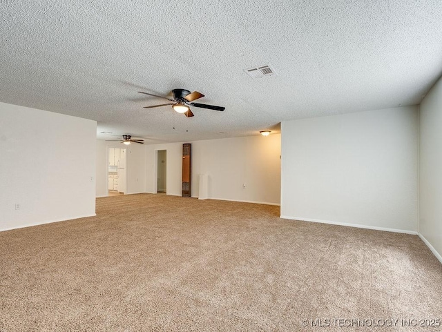 carpeted empty room featuring ceiling fan and a textured ceiling