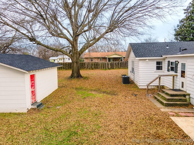 view of yard with central AC and a shed