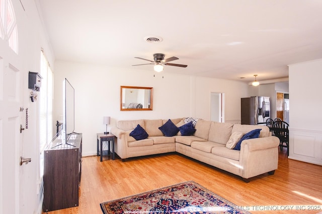 living room featuring ceiling fan and light hardwood / wood-style flooring