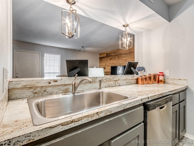 kitchen with pendant lighting, dishwasher, sink, light stone counters, and gray cabinetry