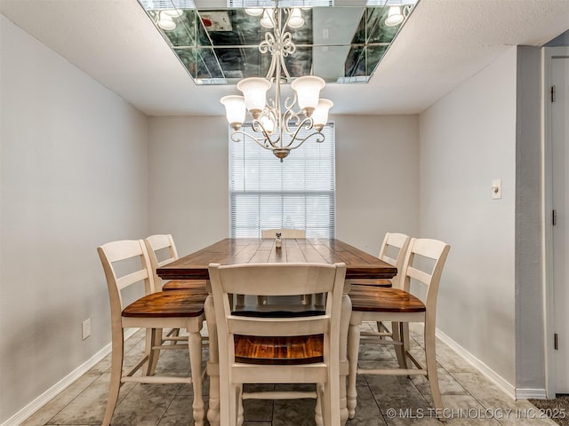 dining area featuring tile patterned floors and a chandelier