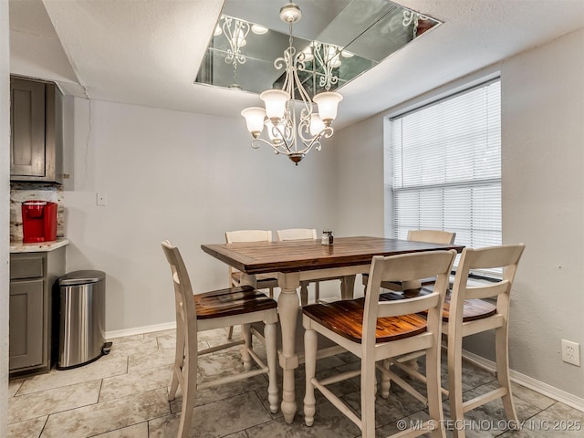 dining area with light tile patterned flooring and a chandelier