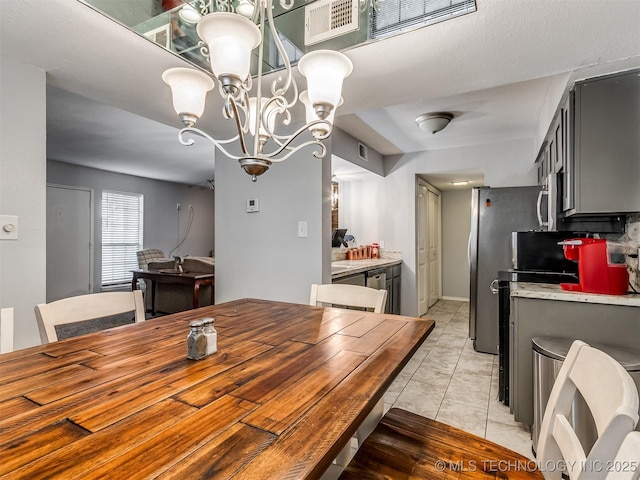 tiled dining room featuring an inviting chandelier