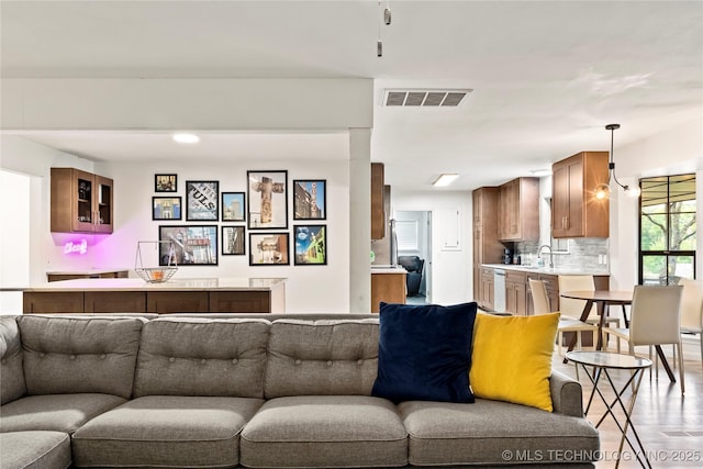 living area featuring light wood-style flooring and visible vents