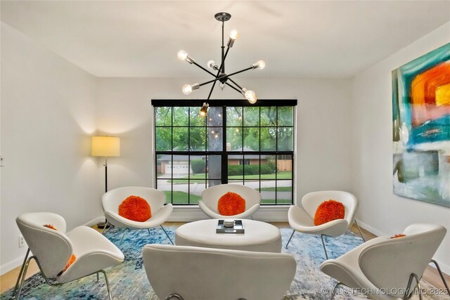 living area with a notable chandelier and baseboards