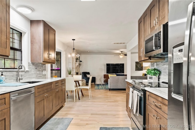 kitchen featuring visible vents, stainless steel appliances, light countertops, light wood-style floors, and a sink