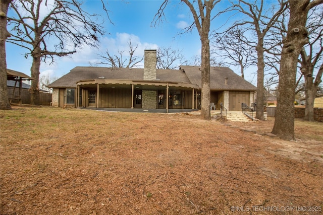 back of property featuring a patio area, a chimney, fence, and board and batten siding