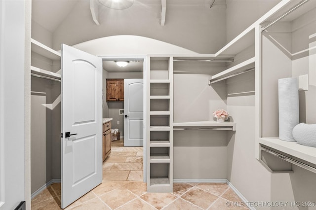 walk in closet featuring stone finish flooring
