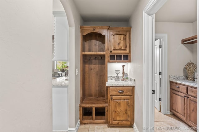 mudroom featuring baseboards and arched walkways