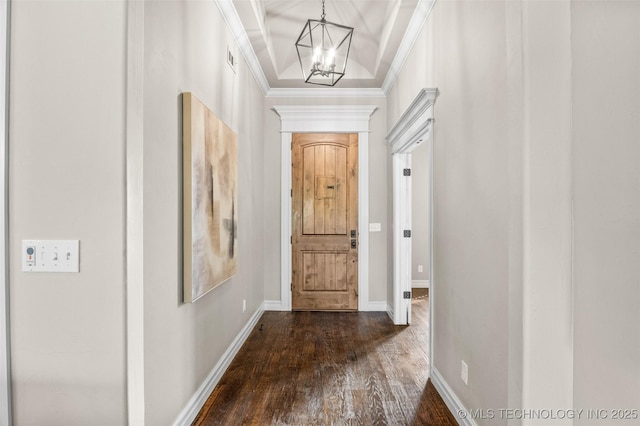 entryway with dark wood-type flooring, baseboards, an inviting chandelier, and crown molding